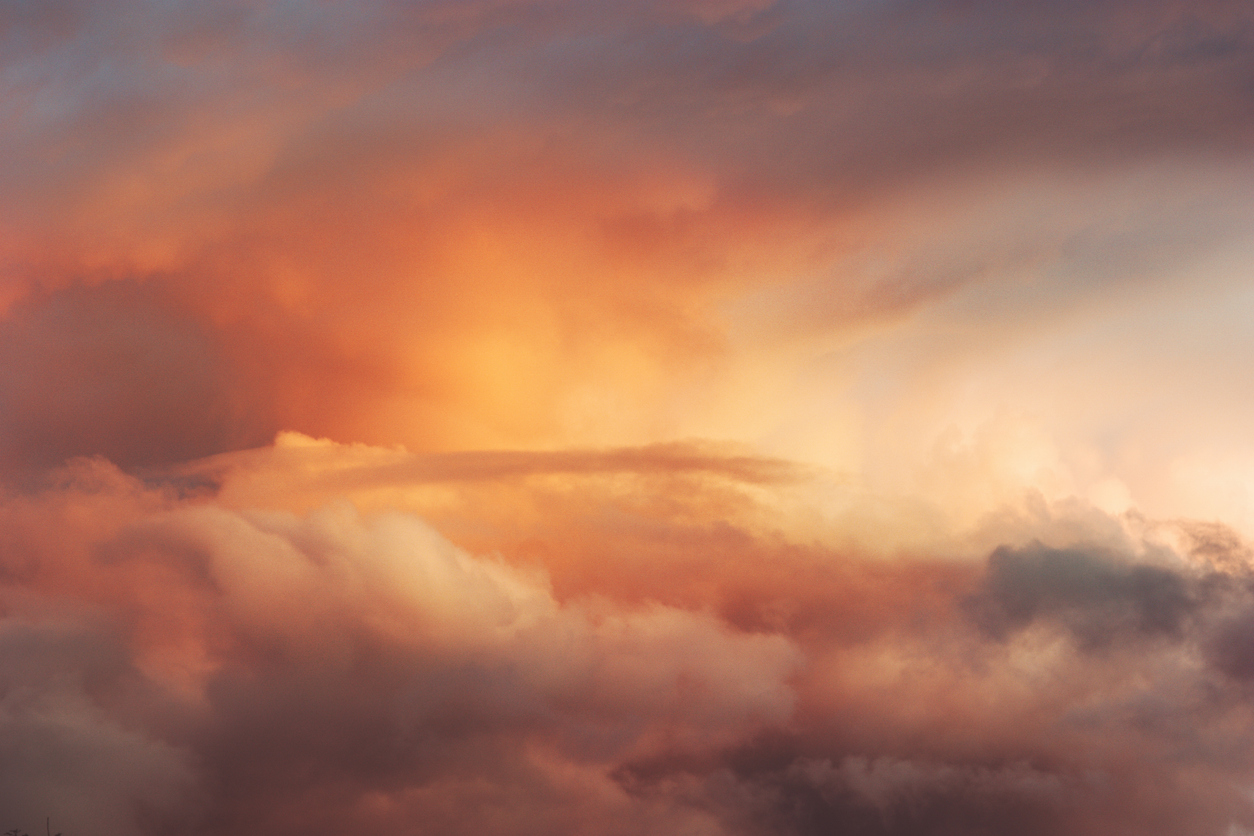 Roze en oranje wolken in een hemel met warm avondlicht.